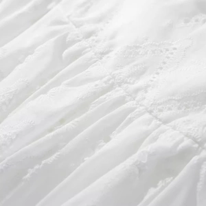 White low waist lace mini skirt featuring delicate eyelet embroidery and ruffle details