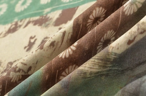 Makro-Detail von Vintage-Stoff mit unregelmäßigem Blumendruck und fließendem Faltenwurf