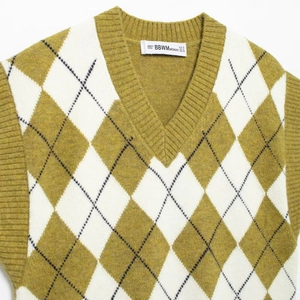 Mustard yellow diamond pattern knitted V-neck vest with ribbed edges flat lay view