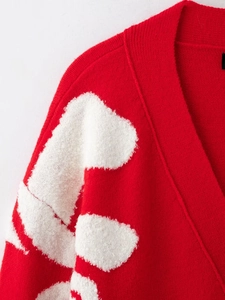 Detailed macro view showing the red knit texture and white fuzzy textured embroidery