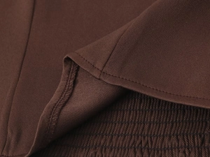 Detailed close-up of brown strapless top showing precise smocking and clean hem stitching