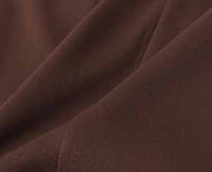 Macro detail of high-quality dark brown twill fabric texture with visible diagonal weave