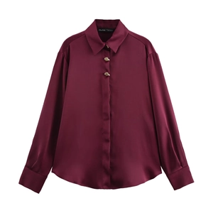 Detailed view of luxury wine red satin blouse featuring unique golden metal buttons