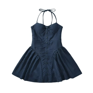 Robe courte dos nu bleu marine à rayures avec boutons et jupe plissée sur fond blanc neutre