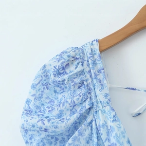 Blue and white porcelain floral dress with lace V-neck and pleated shoulder details