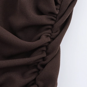 Detailansicht aus dunkelbraunem Strickstoff mit eleganter seitlicher Raffung