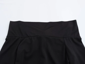 Detailed macro view of the wide elastic waistband on high-waist black knit trousers