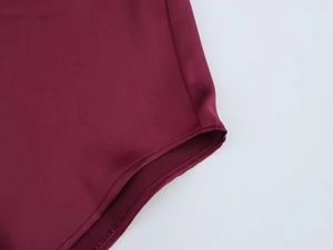 Detailed close-up showing precise double stitching on burgundy satin texture shirt fabric