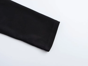 Detail of black off-shoulder top sleeve featuring precision stitching and premium fabric