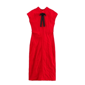 Détail d'une robe rouge sans manches avec col montant et nœud en satin noir élégant