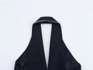 Detail of black halter top neckline featuring elegant white lace trim and V-neck design
