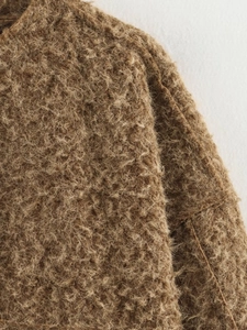 Détail de la texture en fausse laine marron et coutures d'épaule sur cette veste femme