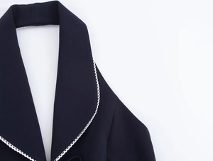 Detail of navy halter top with white lace trim and blazer lapels for 2025 fashion