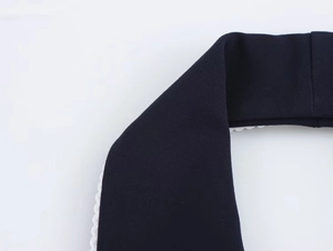 Detailed macro view of navy twill fabric with contrast white scalloped lace edge
