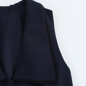 Macro detail of dark blazer lapel with elegant black lace trim and matte fabric texture