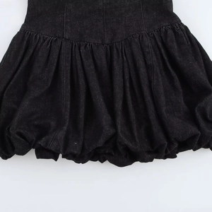 Détail de l'ourlet bouffant et des coutures verticales sur la jupe en denim noir