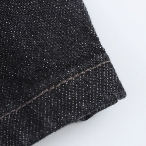Gros plan sur les coutures professionnelles et la texture sergée du denim noir