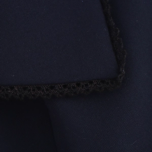 Macro shot of navy blue twill fabric texture with intricate lace trim sewing details