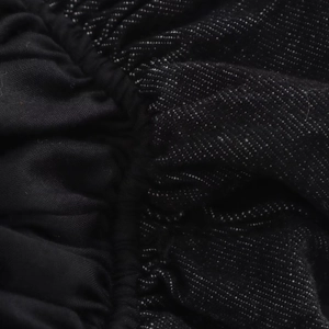 Détail de tissu plissé noir cousu avec une matière en denim texturé à pois blancs