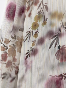 Détail du tissu en mousseline florale avec des rayures verticales dorées en lurex