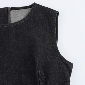 Détail d'une robe en jean sans manches à col rond montrant la texture du sergé et la couture