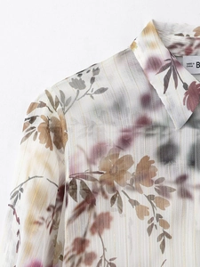 Détail de chemisier en mousseline florale avec rayures dorées et col à revers classique