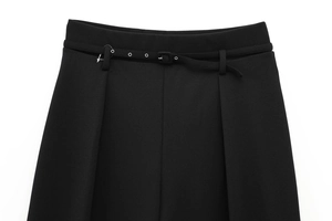 Detailed close-up of high-waisted black trousers featuring a thin belt and metal eyelets