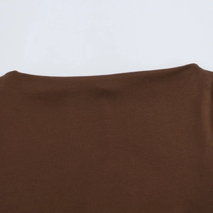 Detail of the brown knit dress showing elegant boat neck design and fine ribbed texture