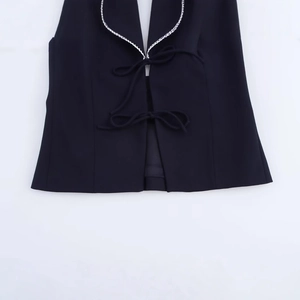 Women's black halter top featuring white braided trim and elegant bow-tie closures
