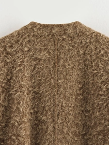 Détail d'un manteau en fausse fourrure marron avec couture dorsale et texture