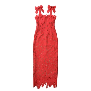 Detailed close-up of intricate red lace texture and bow straps on the dress