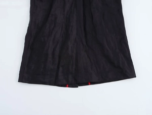 Vue détaillée de l'ourlet de la robe noire avec des rayures rouges emblématiques