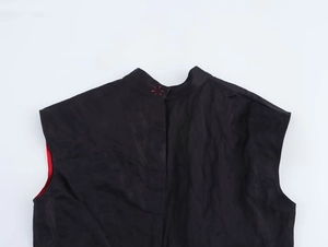 Détail de la broderie rouge et de la doublure sur le gilet noir de style cosplay