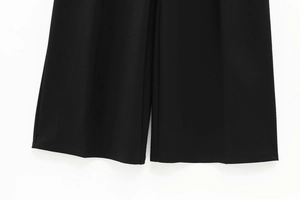 Detail of high-waist wide-leg pants showing smooth fabric and neat bottom hem stitching