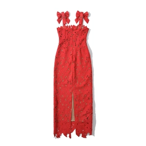 Detail of red floral lace dress featuring satin shoulder bows and a slit hemline