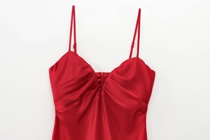 Détail de la robe midi en satin rouge avec bretelles réglables et décolleté plissé
