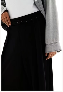 Detail view of high waist black wide leg trousers featuring a belted waist with silver eyelets