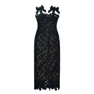 Detail of elegant black lace dress featuring delicate bow straps and floral embroidery