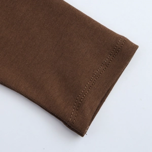 Detail of ribbed cuffs on dark brown knit dress with high-elastic double stitching