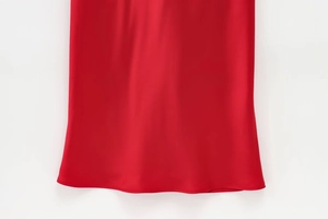 Vue détaillée de l'ourlet de la robe en satin rouge avec finition de couture soignée