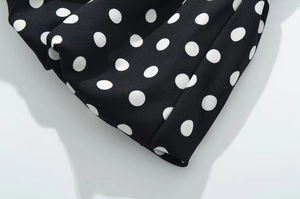 Detail of ruffled hem with white polka dots on lightweight black chiffon fabric