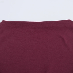 Detailed close-up of dark red knitted fabric with high-quality seamless waist stitching