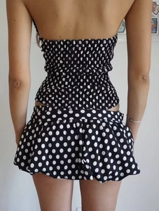 Detail showing the back view of a black and white polka dot two-piece ruffle shorts set