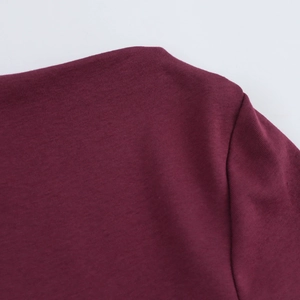 Close-up of wine red knitted dress showing fine shoulder stitching and neckline texture