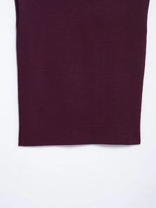 Dettaglio ravvicinato della trama in maglia rosso vino con cuciture fini e drappeggio