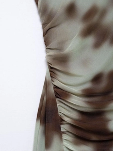 Detailed close-up of ruched sheer mesh fabric with brown and green gradient pattern