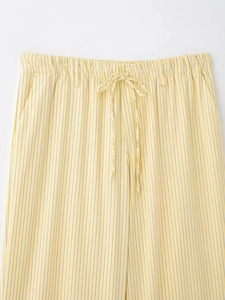 Détail d'un pantalon rayé avec taille élastique à cordon et texture plissée élégante