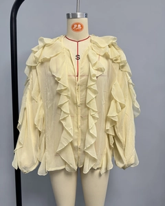 Detail of light yellow chiffon blouse featuring tiered ruffles on neckline and sleeves