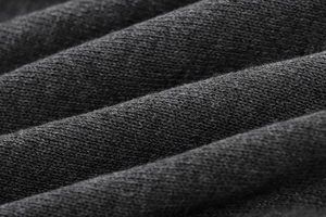 Gros plan sur un tissu en maille gris foncé montrant la texture détaillée du tricot