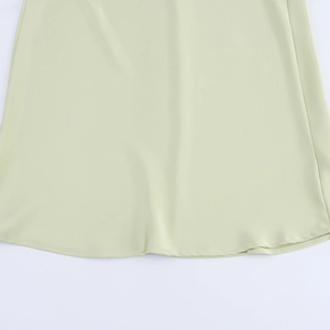 Détail de l'ourlet de la robe midi en satin vert clair avec coutures fines et beau drapé